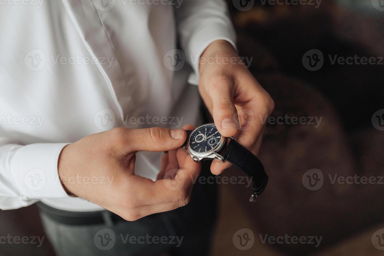 A man is holding a watch in his hand photo