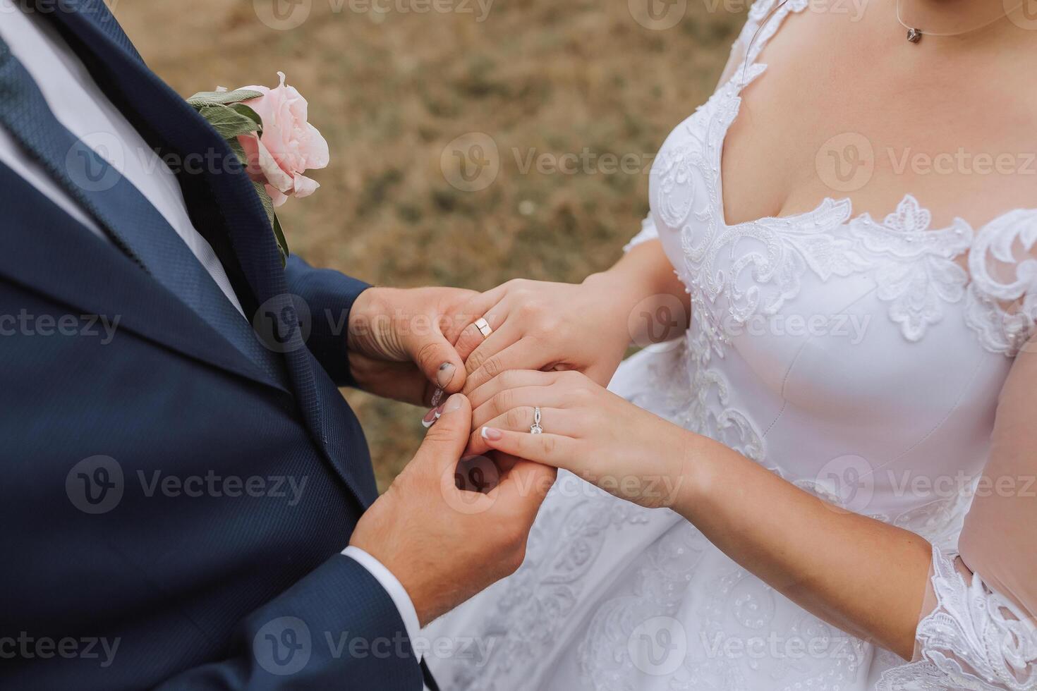 A bride and groom are getting married and the bride is wearing a white dress photo
