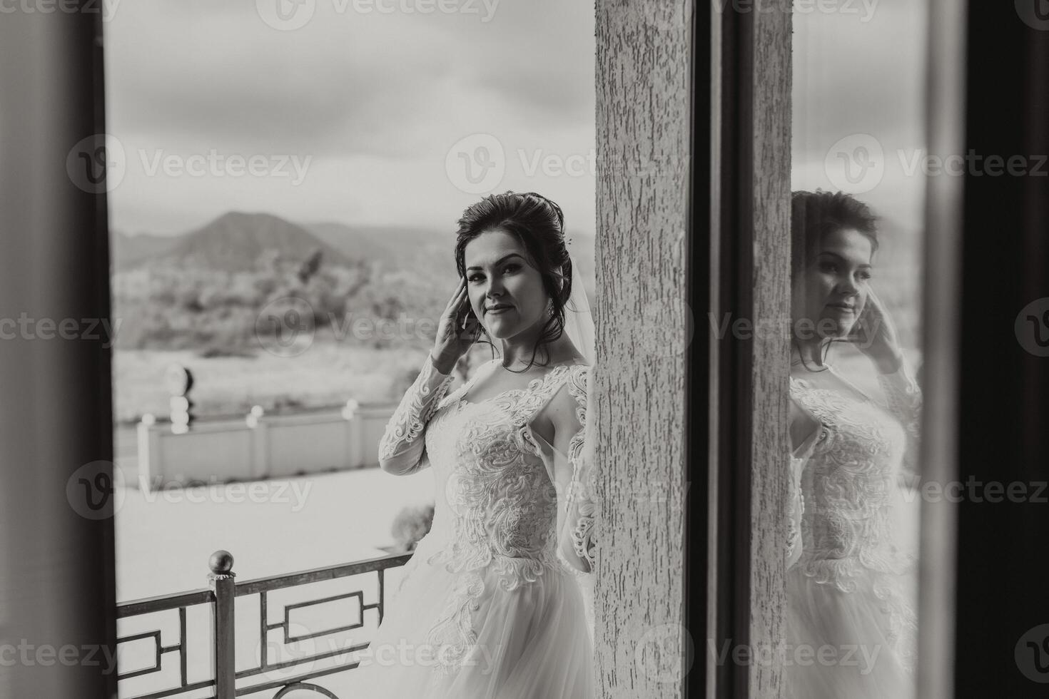 A woman in a wedding dress is standing in front of a window photo