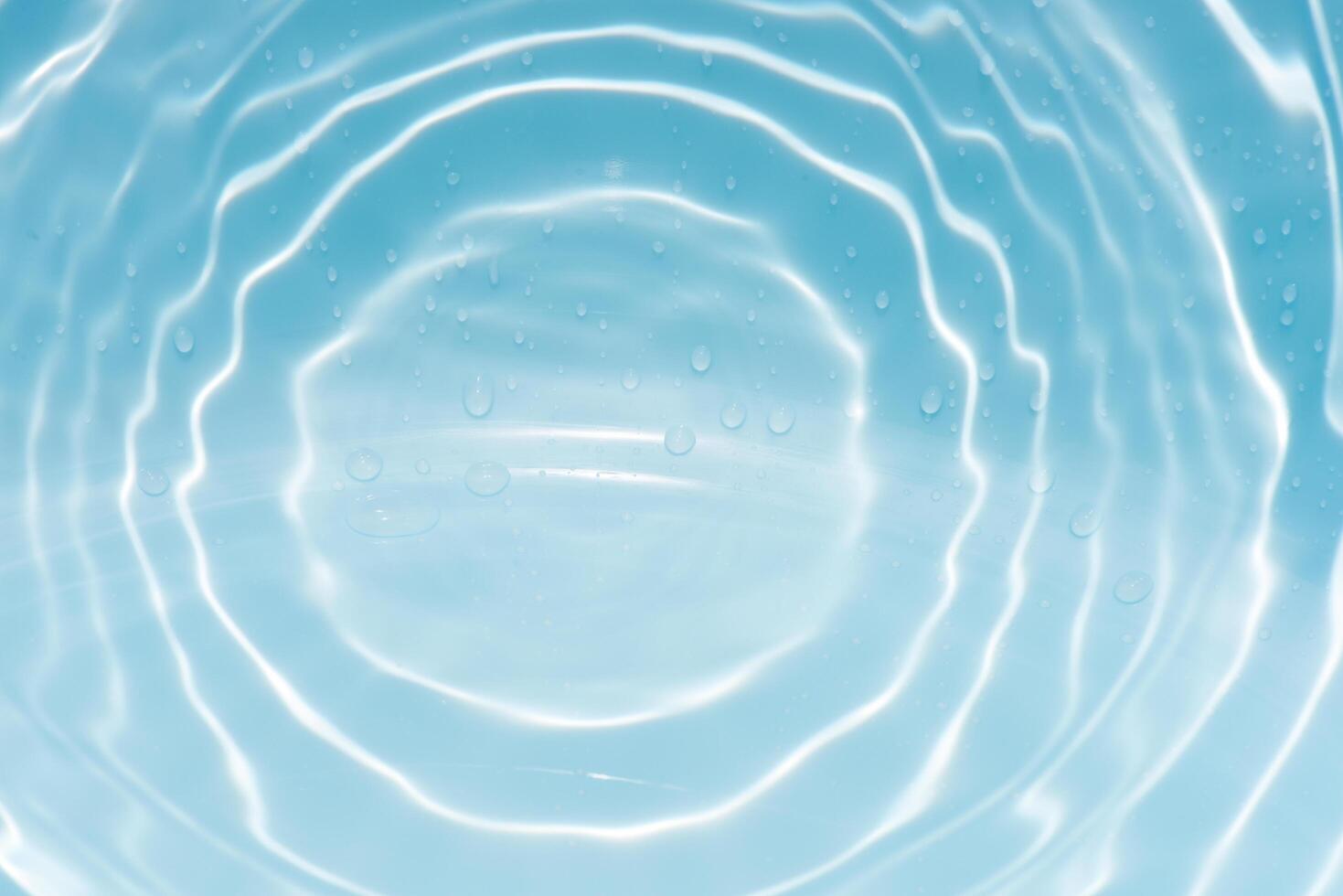 Blue water with ripples on the surface. Defocus blurred transparent blue colored clear calm water surface texture with splashes and bubbles. Water waves with shining pattern texture background. photo