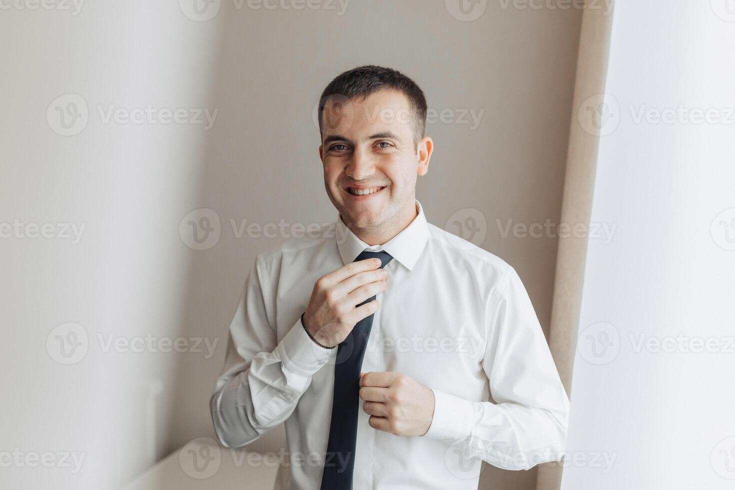 A man is wearing a white shirt and a black tie photo