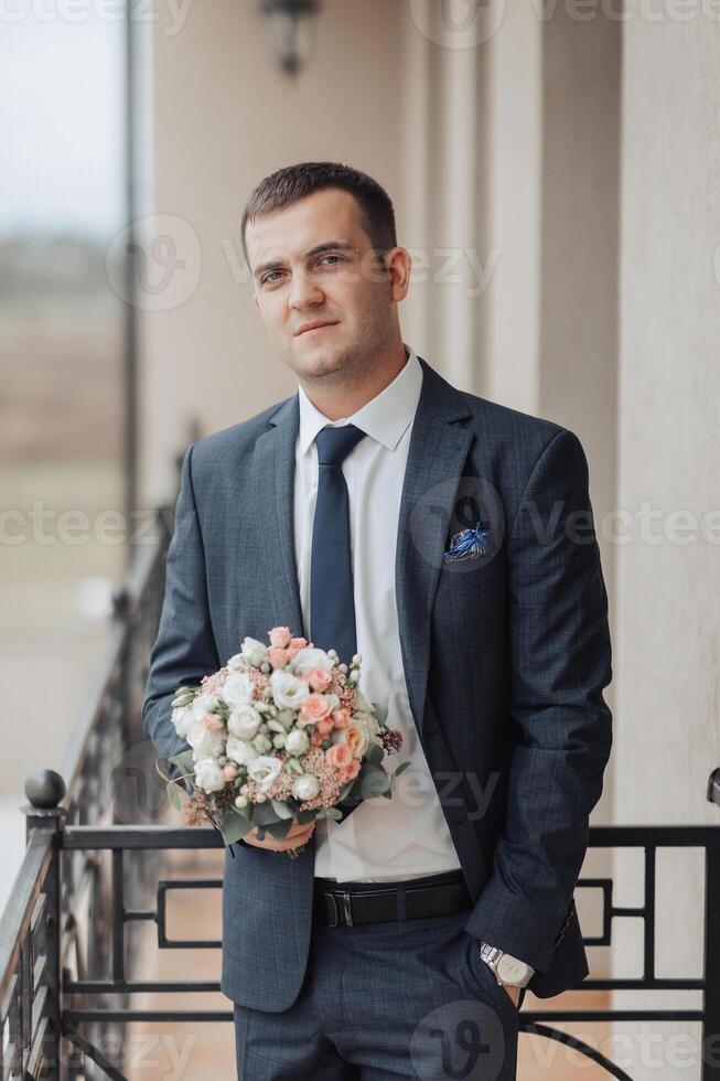 A man in a suit holding a bouquet of flowers photo