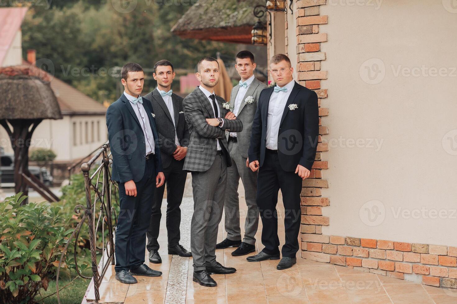 A group of men in suits are standing on a brick wall photo