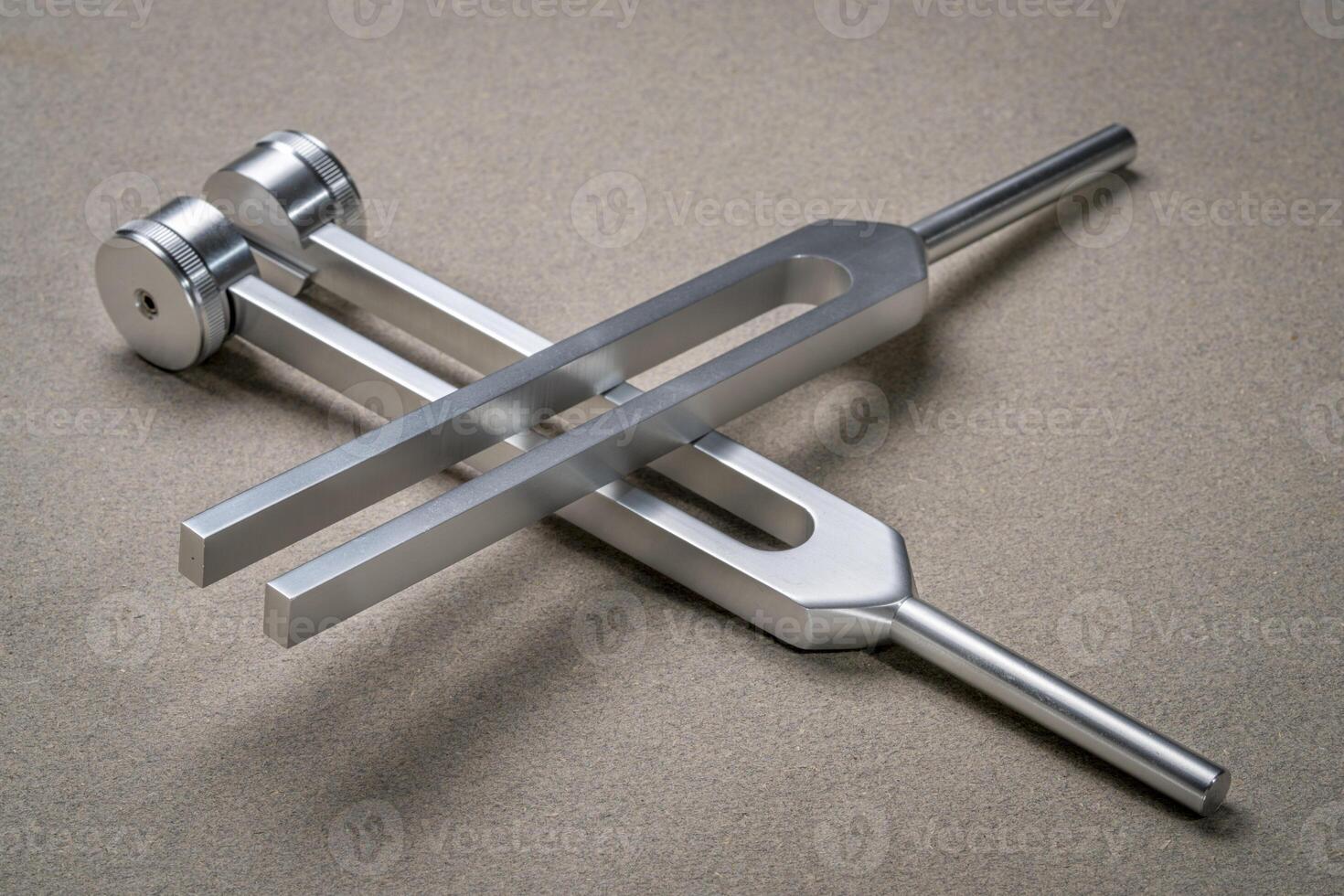 Weighted and unweighted metal tuning forks used for tuning musical instruments, sound therapy, chakra healing or relaxation. photo