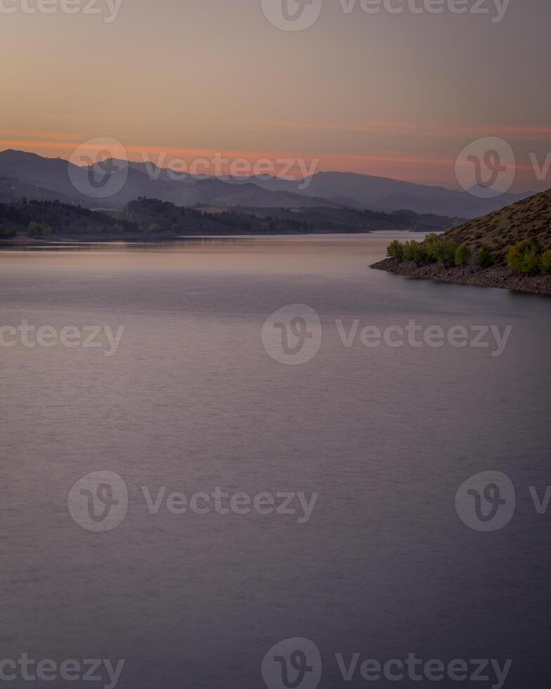 dusk over calm waters of Horsetooth Reservoir at foothills of Rocky Mountains in Colorado photo