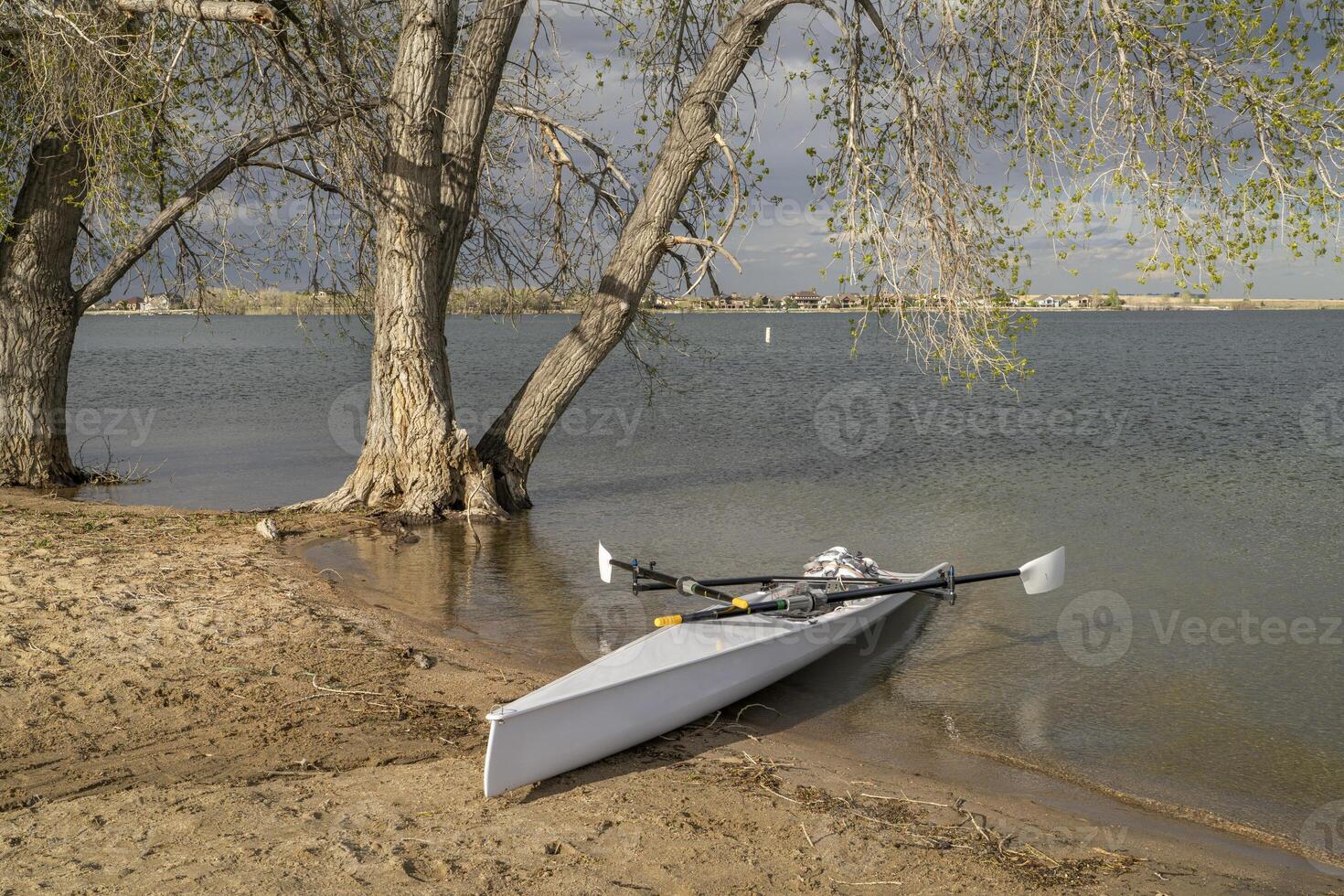 Coastal rowing shell on a shore of Boyd Lake in northern Colorado in early spring scenery. photo