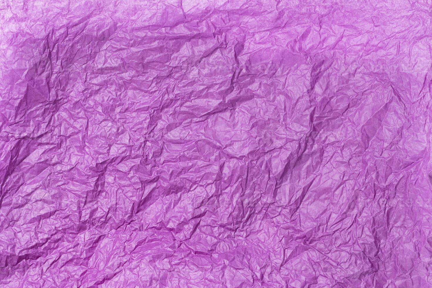 Crumpled purple tissue paper with textured folds photo