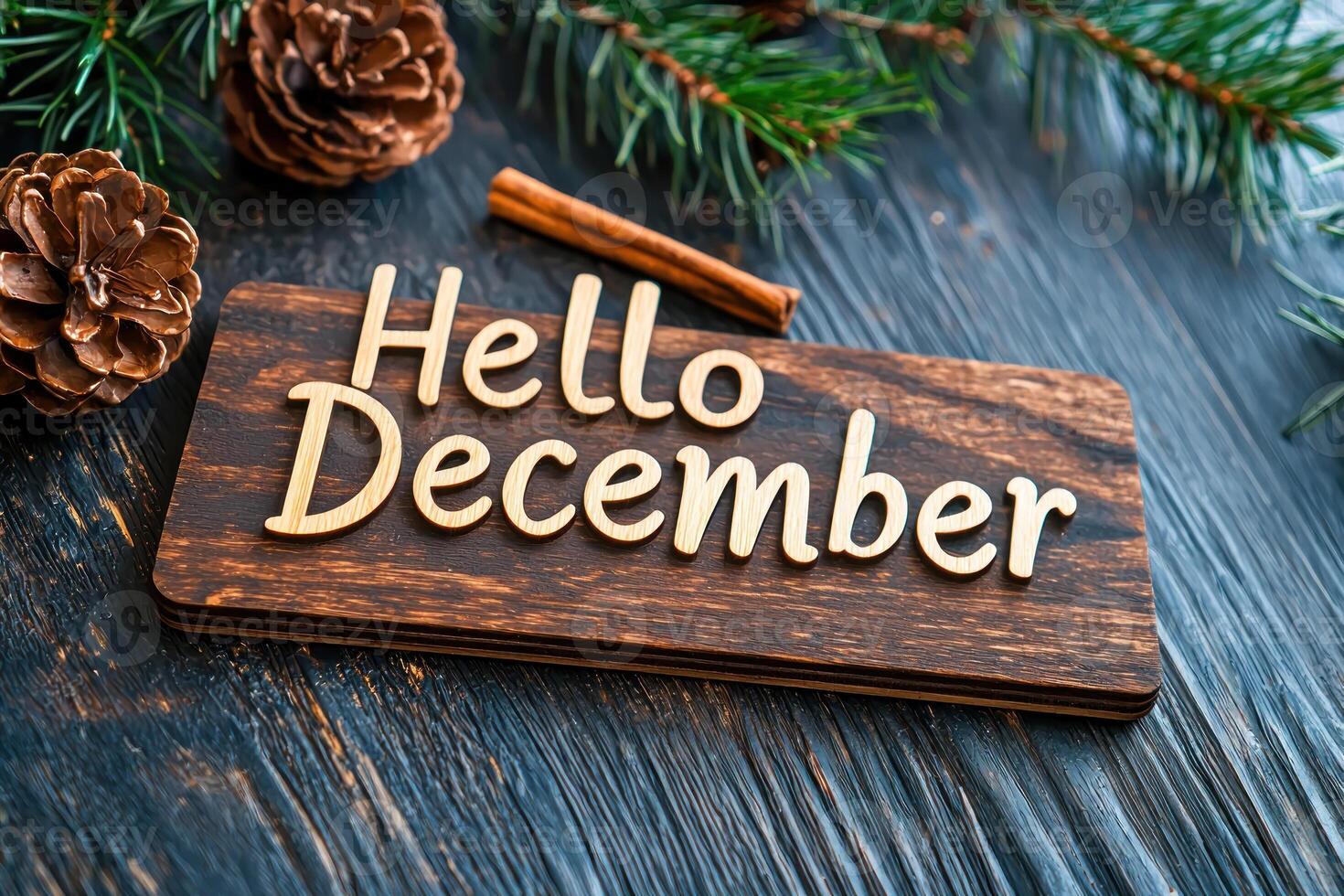 Hello December sign with rustic wooden background and pine cones photo