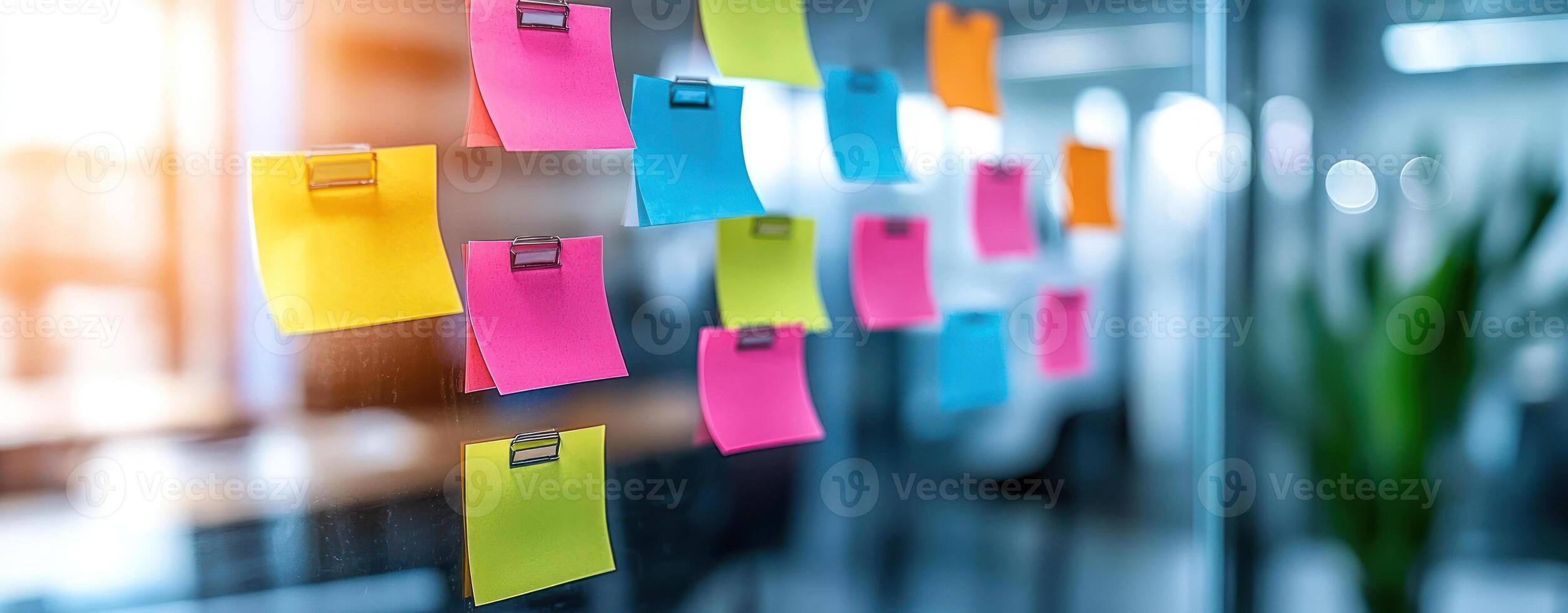 Brainstorming session with colorful sticky notes on glass wall photo
