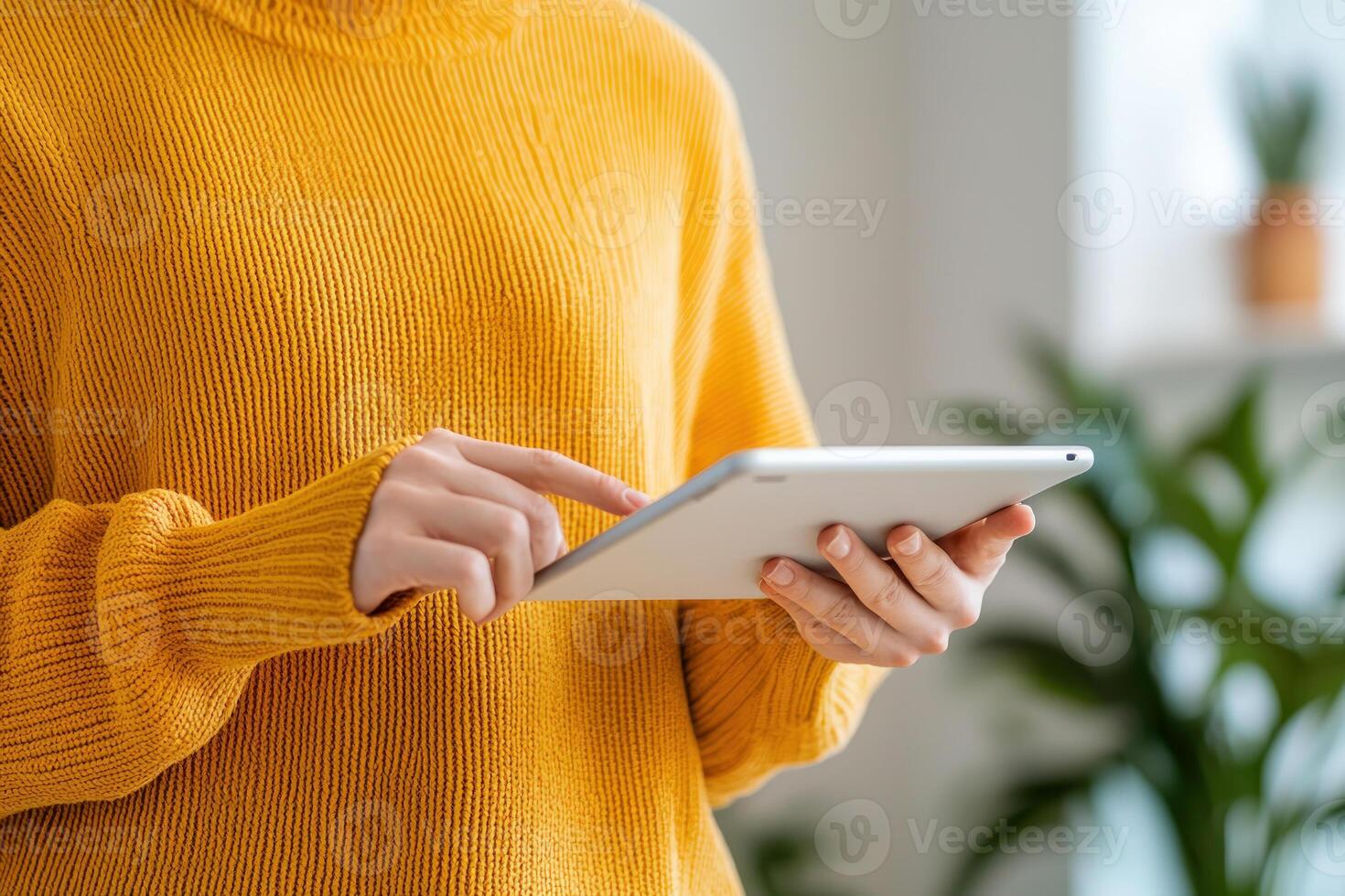 Engaged person using tablet in cozy indoor setting with plants photo