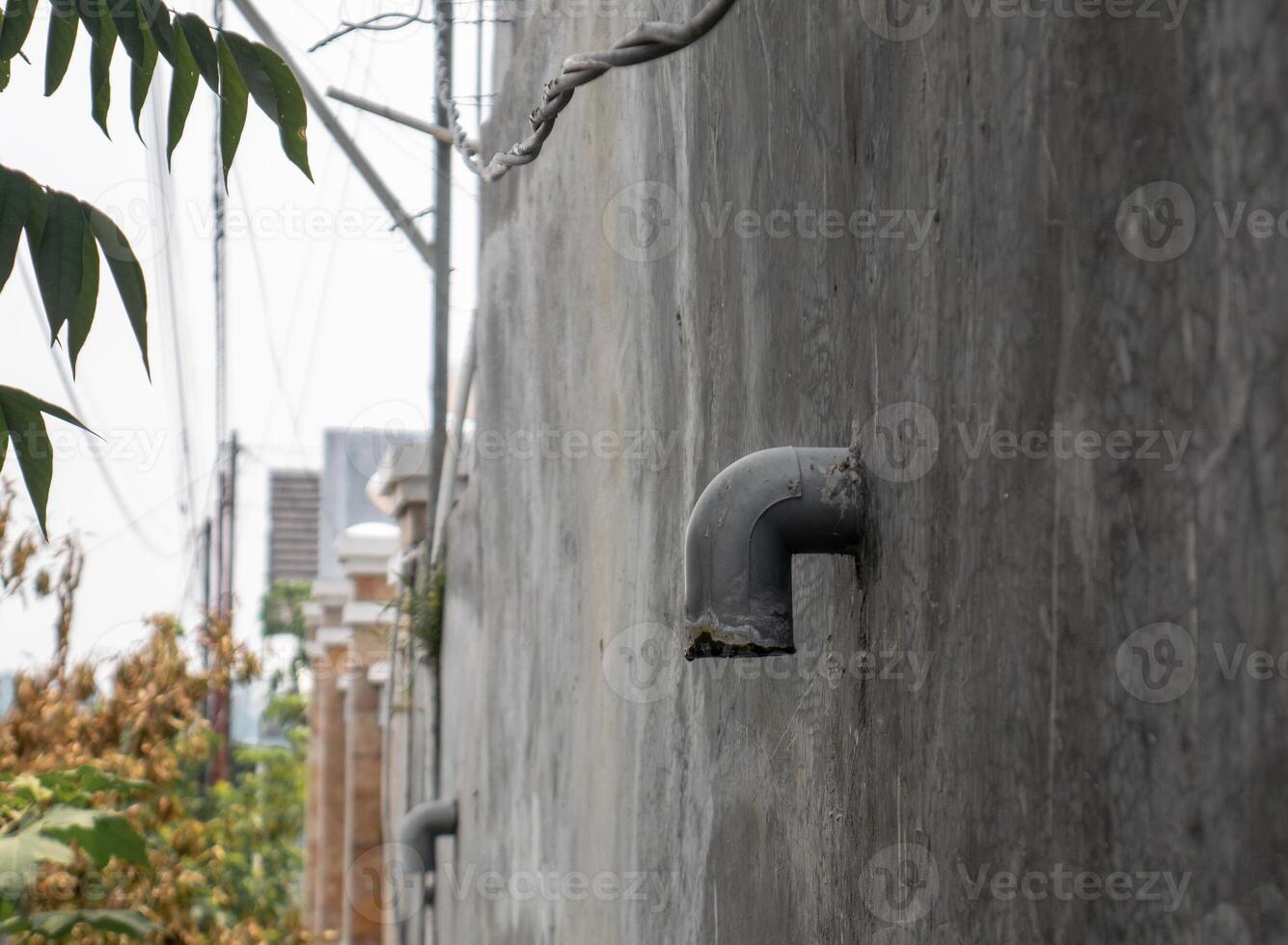 a pipe that comes out of the wall is used for drainage photo