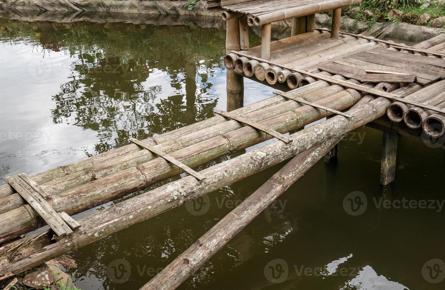 a simple bridge made of bamboo in a damaged and old condition photo