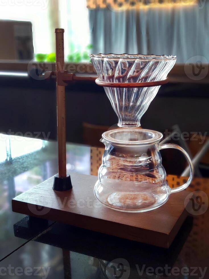 Set of pourover coffee server including heat resistant glass dripper mug, reusable filters or clever dripper, and wooden stand bracket holder, hand drip machine photo
