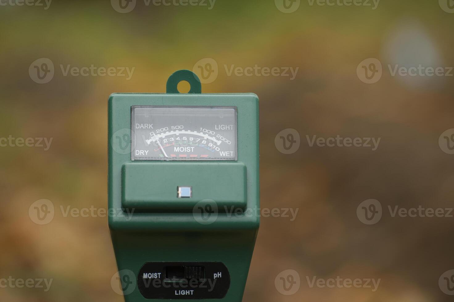Close-up of a soil moisture and pH meter in a garden setting to monitor plant care conditions photo