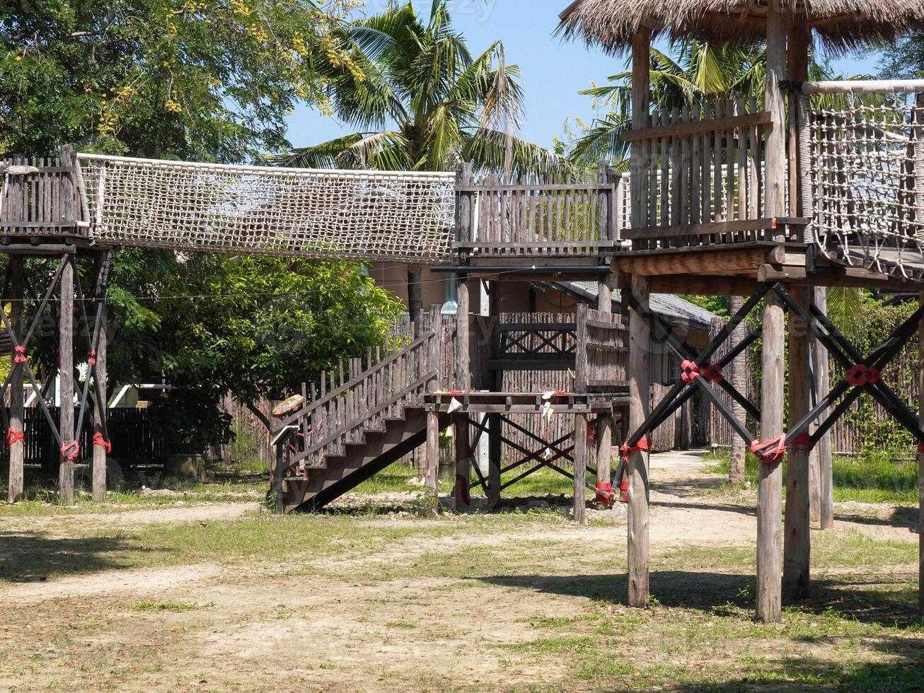 Summer park playground with swings, slides and climbing equipment. Modern wooden playground equipment for children's amusement park. photo