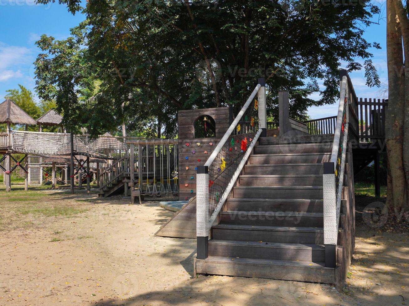 Summer park playground with swings, slides and climbing equipment. Modern wooden playground equipment for children's amusement park. photo