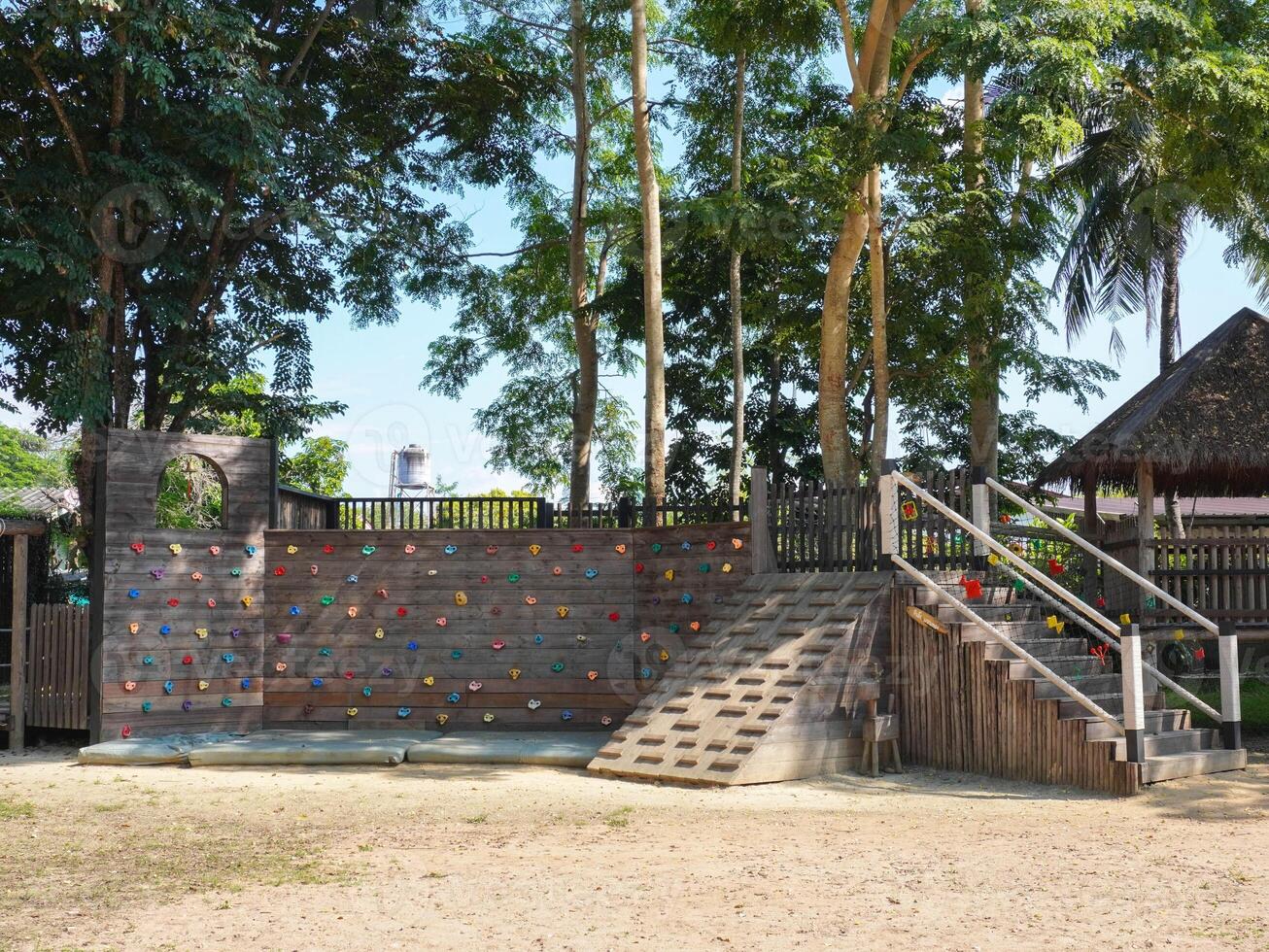 Summer park playground with swings, slides and climbing equipment. Modern wooden playground equipment for children's amusement park. photo