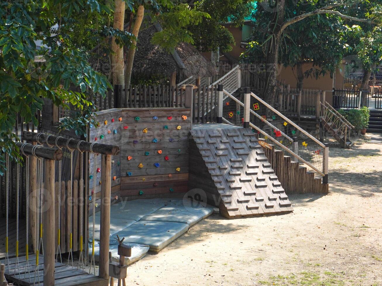 Summer park playground with swings, slides and climbing equipment. Modern wooden playground equipment for children's amusement park. photo