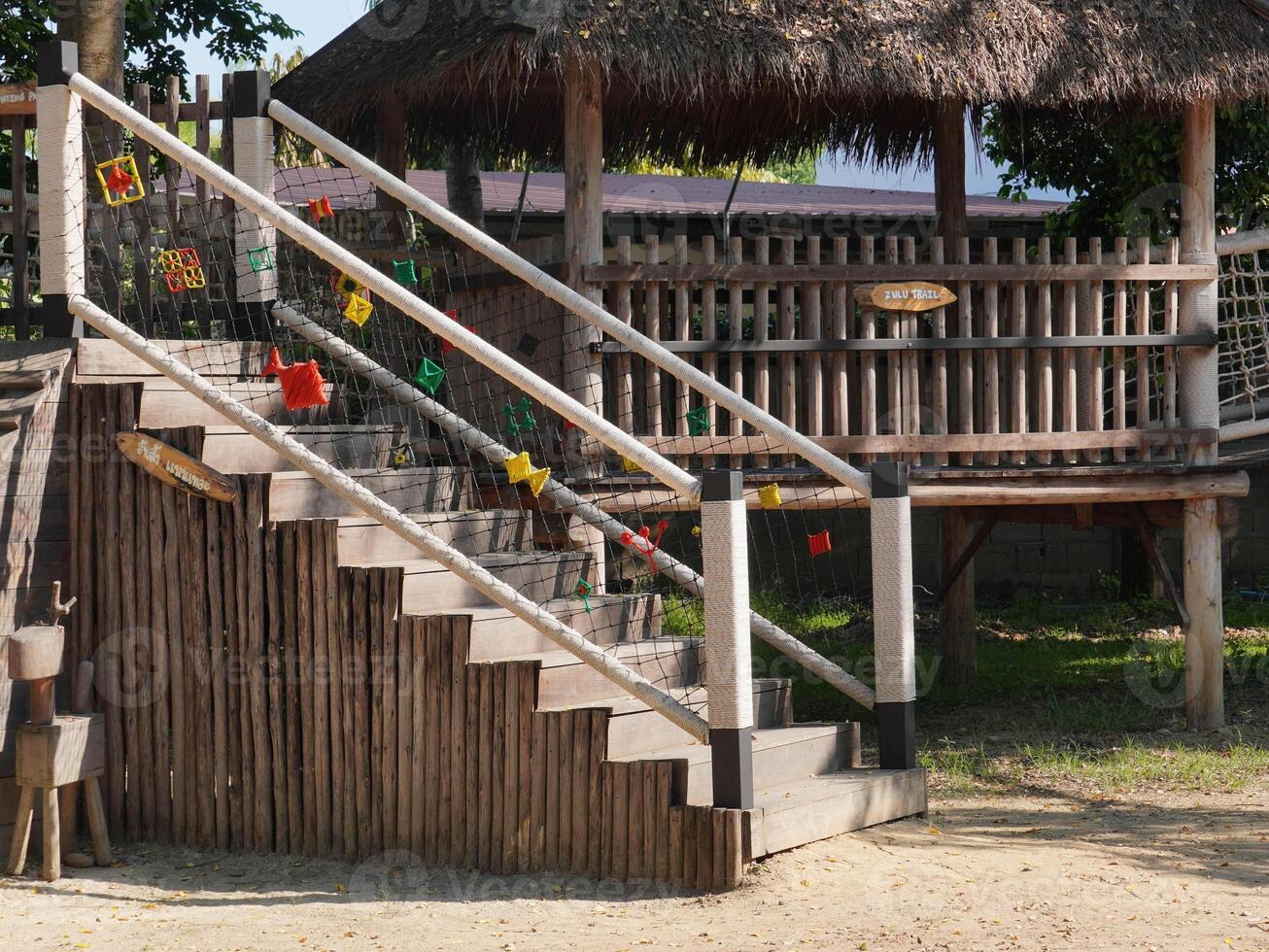 Summer park playground with swings, slides and climbing equipment. Modern wooden playground equipment for children's amusement park. photo