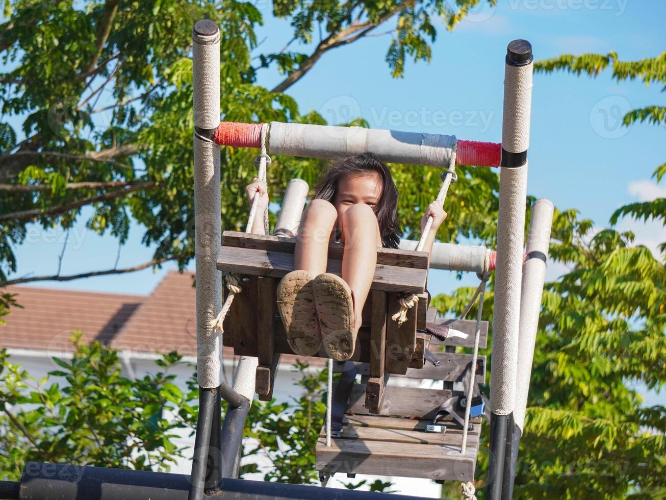 Kids play outdoors on a playground with modern slides, rope net bridges, climbing swings, climbers in summer. photo