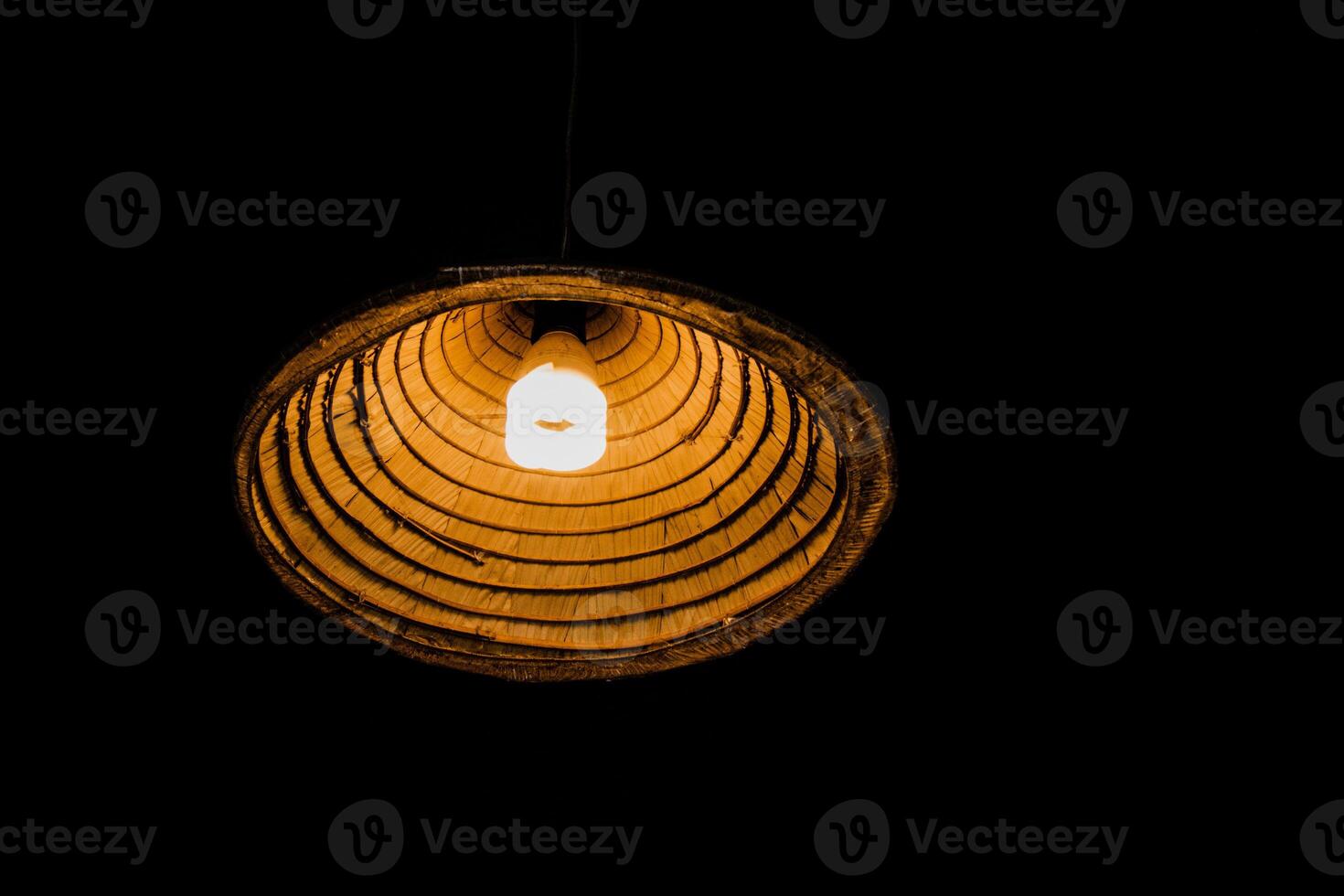 A light bulb is hanging from a wooden lamp photo