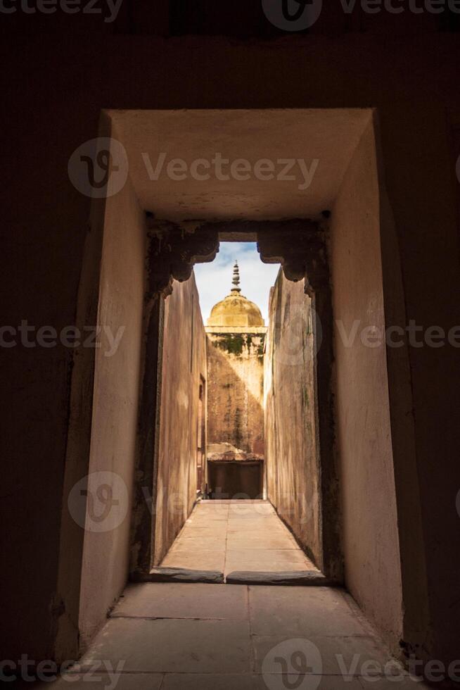 A doorway leading to a courtyard with a dome in the background photo
