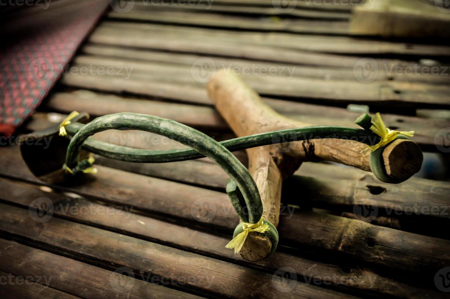 A pair of wooden sticks with green and yellow ribbons tied to them photo