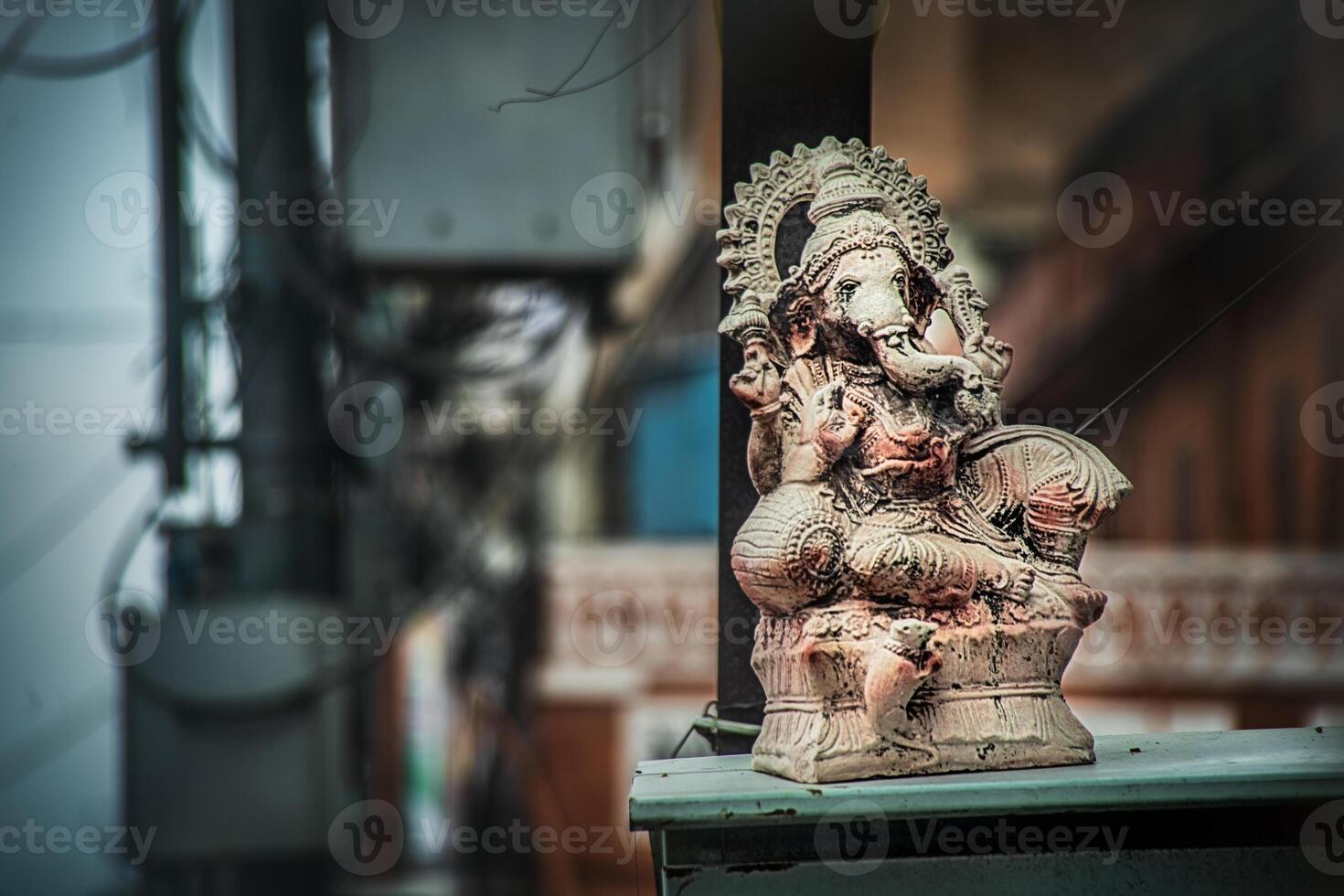 A statue of an elephant sitting on a ledge photo
