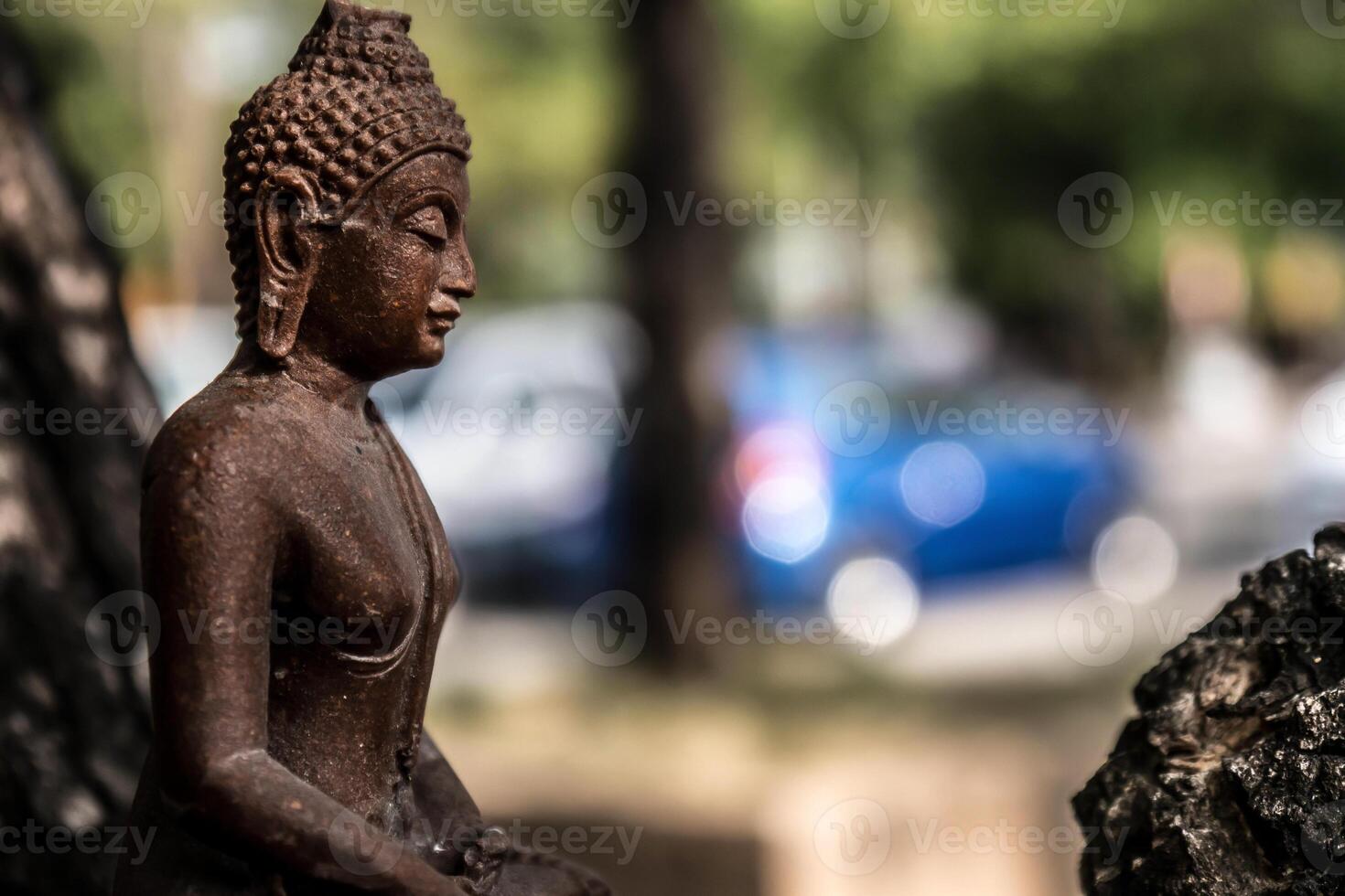 A statue of a buddha sitting on a rock photo