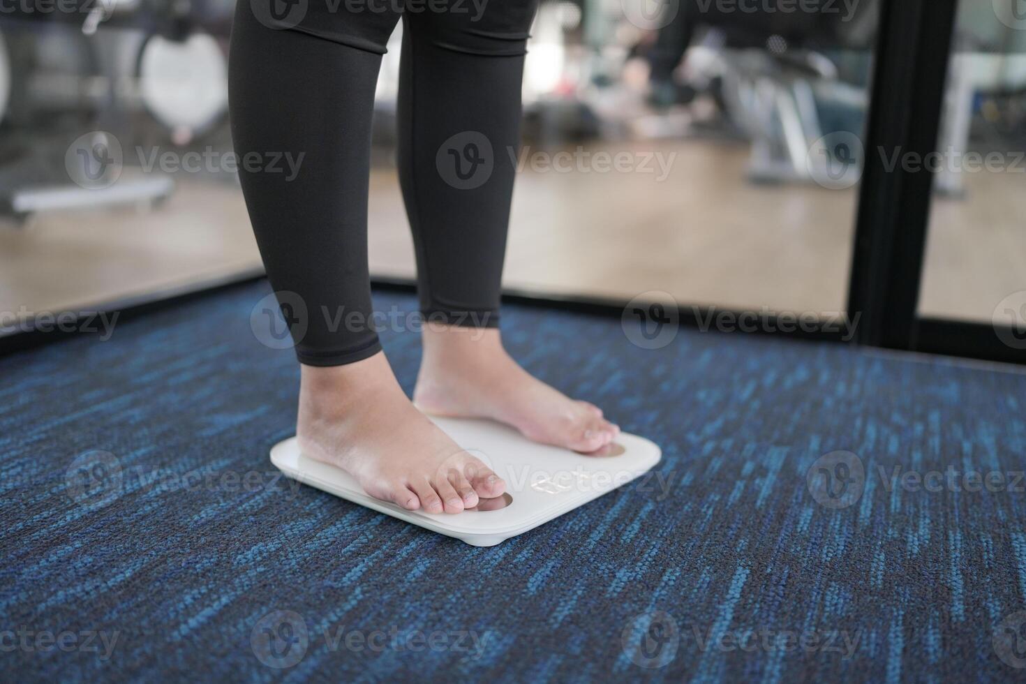 Fat diet and scale feet standing on electronic scales for weight control. Measurement instrument in kilogram for a diet control. photo