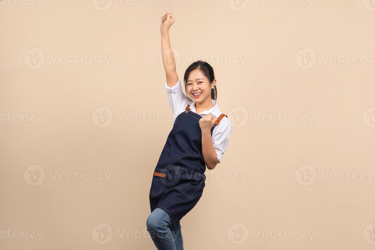 Portrait of asian woman wearing apron on yellow background photo