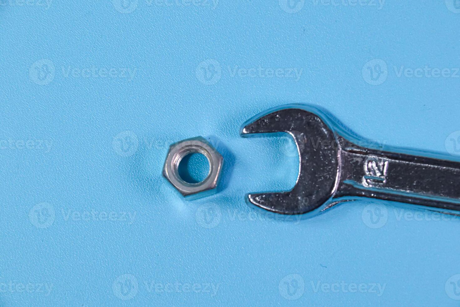 nuts hexagon and wrench on blue background photo
