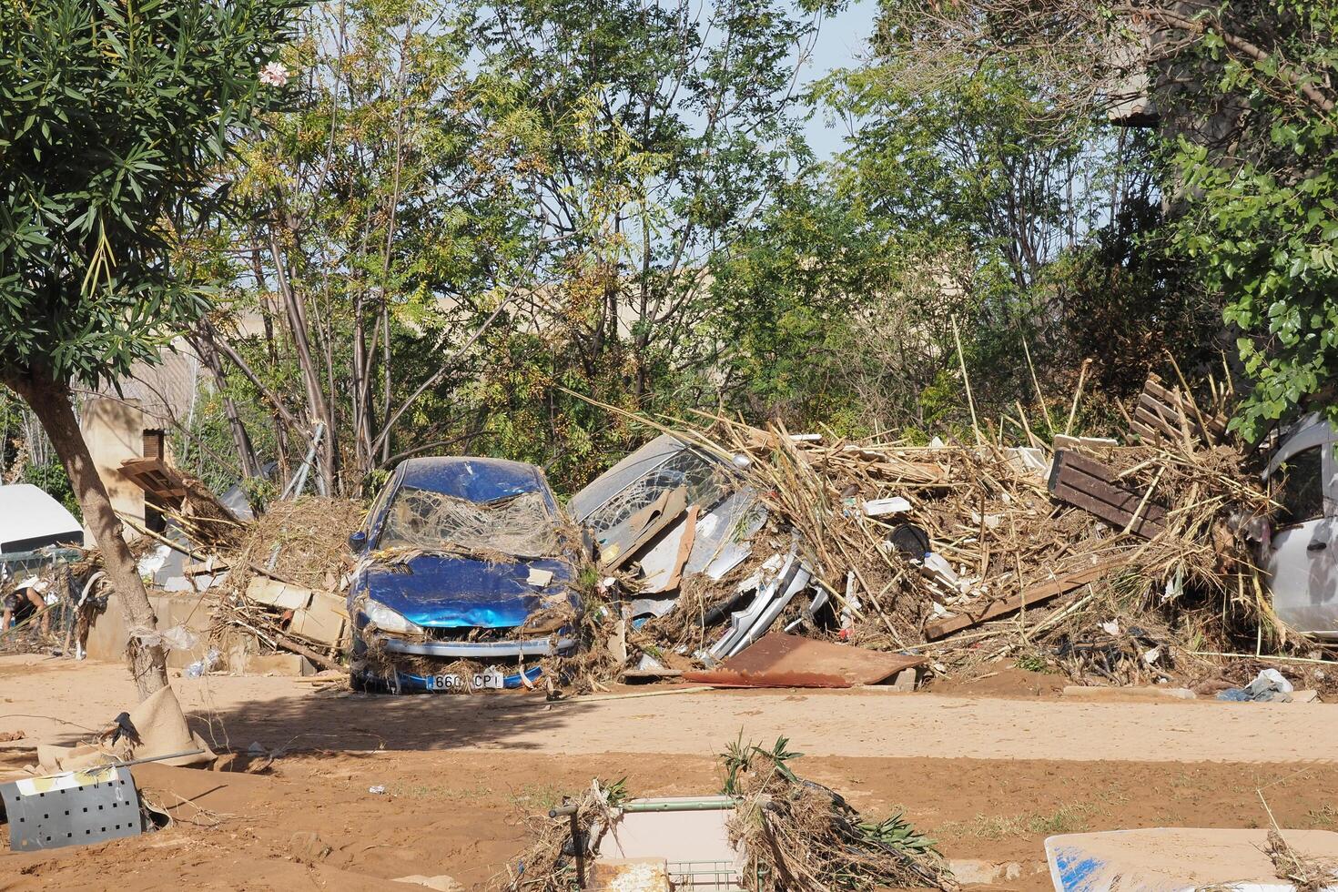 VALENCIA, SPAIN OCTOBER 31, 2024. Cars covered in mud and debris illustrating the devastating aftermath of flooding in a residential area of Valencia photo