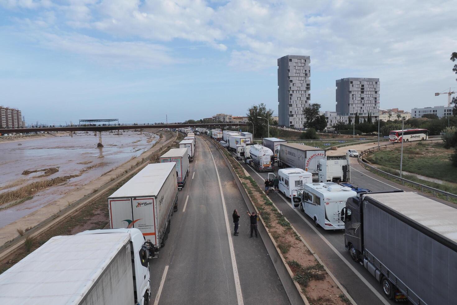 VALENCIA, SPAIN OCTOBER 31, 2024. Truck drivers standing on a highway next to their vehicles, blocked by the flooding of the turia river in Valencia, Spain photo