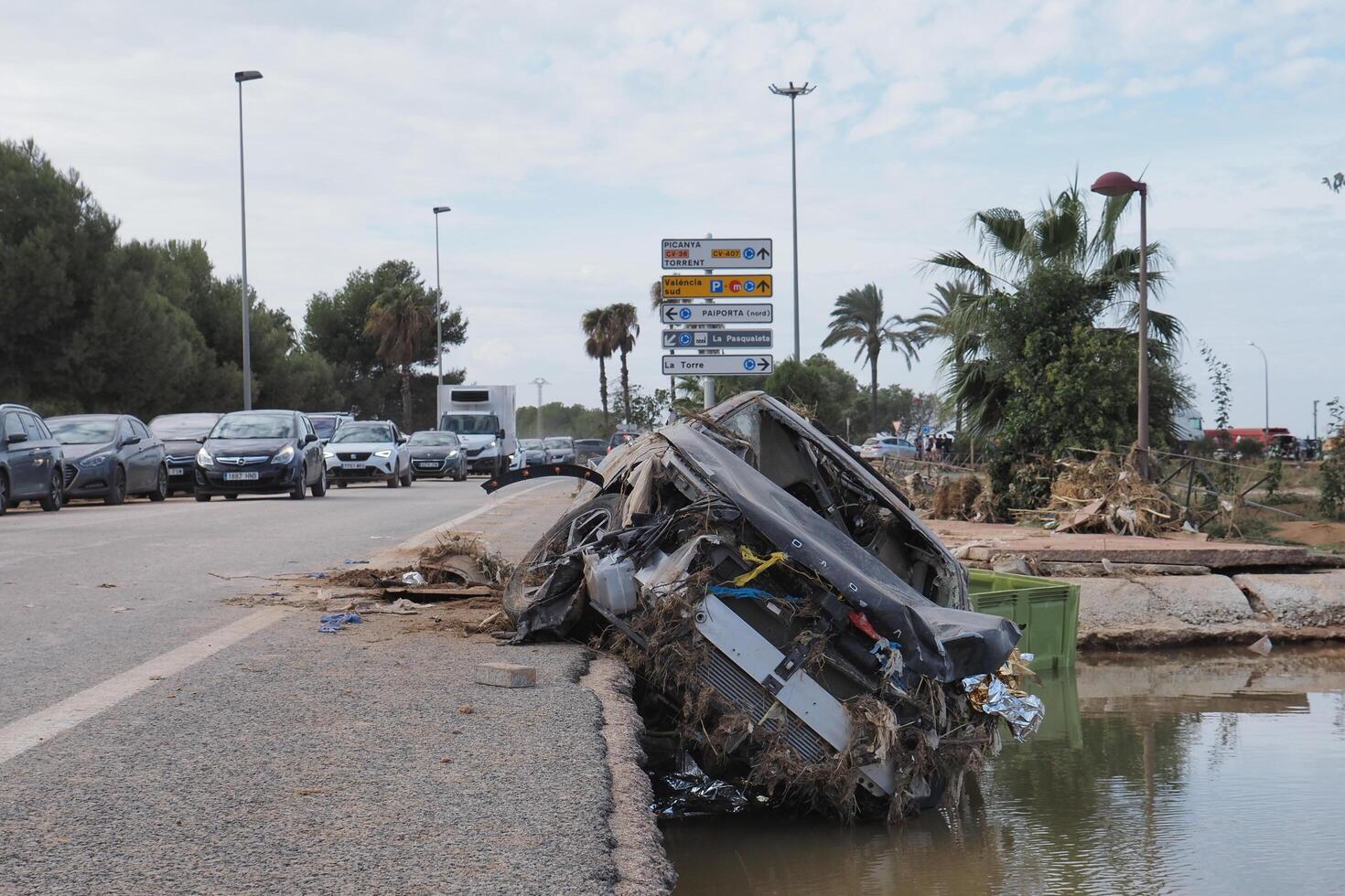 VALENCIA, SPAIN OCTOBER 31, 2024. Devastating consequences of flooding showing destroyed car lying on roadside in Valencia, Spain photo