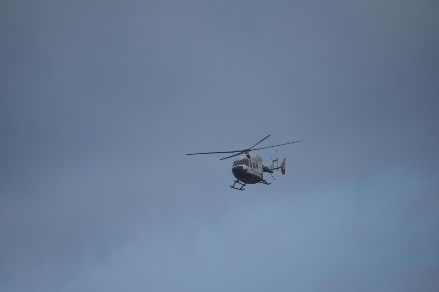 VALENCIA, SPAIN OCTOBER 31, 2024. Rescue helicopter patrolling flooded area in Valencia, Spain, providing aerial support during natural disaster photo