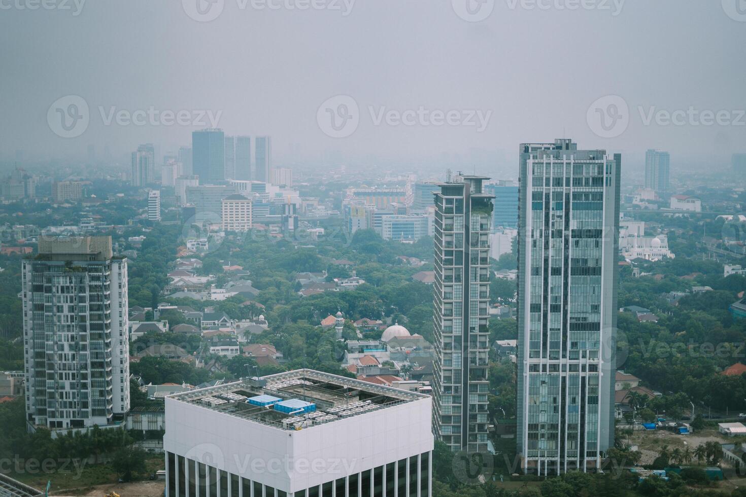 High-rise buildings and a major road in Jakarta city, with visible air pollution creating a hazy urban atmosphere photo