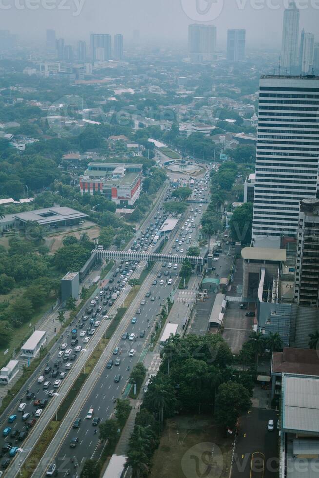 High-rise buildings and a major road in Jakarta city, with visible air pollution creating a hazy urban atmosphere photo