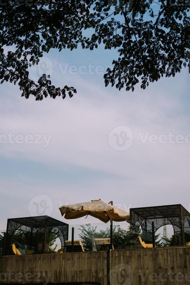 Beautiful outdoor hotel area featuring elegant landscaping, lush greenery, and comfortable seating, photo