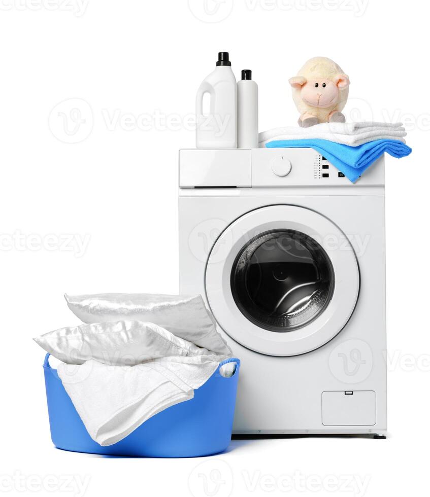 Laundry Detergent Bottles, Sheep Toy, and Towels on Top of a White Washing Machine photo