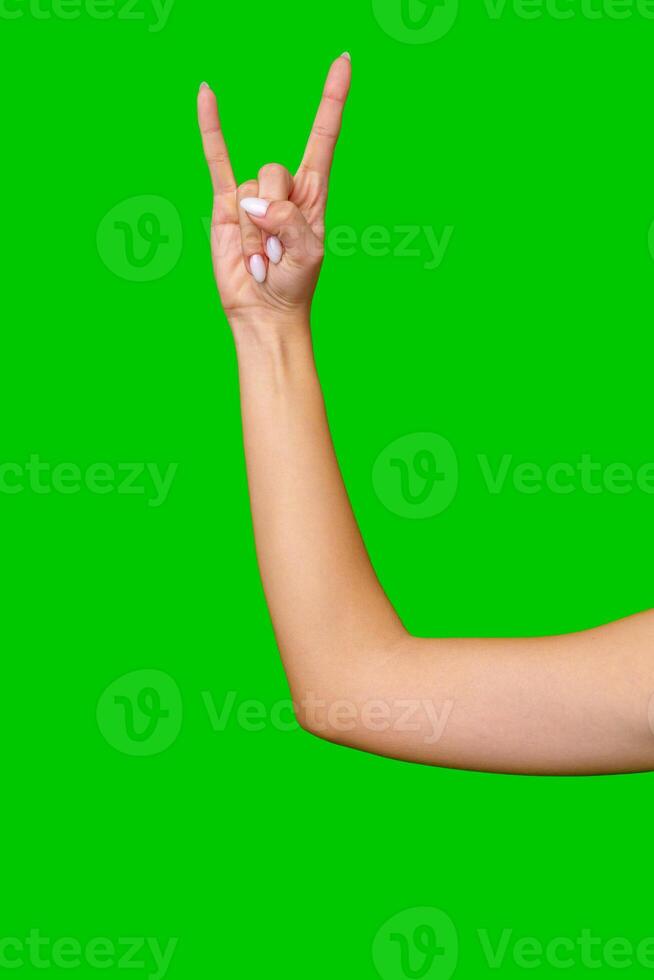 Closeup of Woman's Hand Making the Rock and Roll Sign Against a Green Screen photo