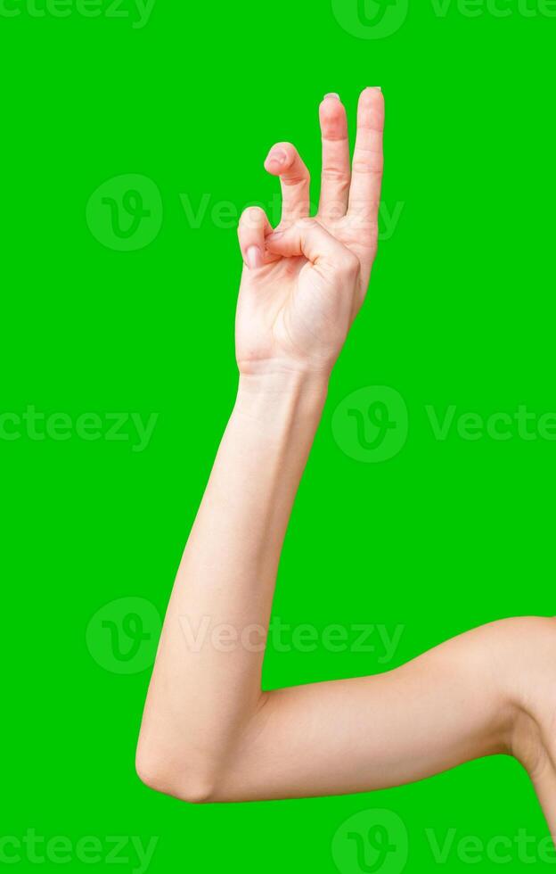 Close-Up of a Woman's Arm Making a Hand Gesture Against a Green Screen photo