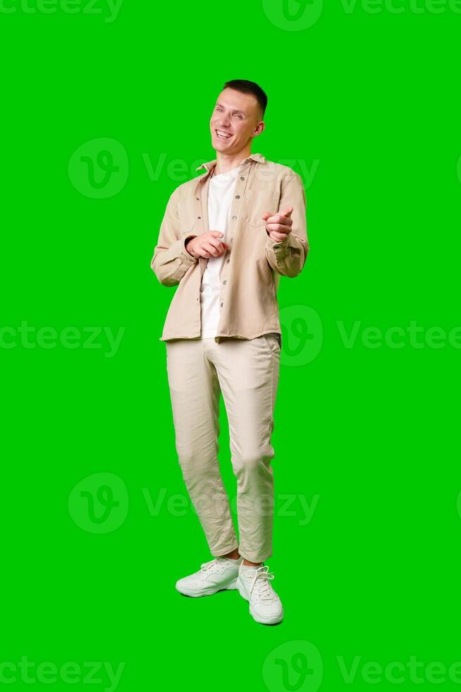 Young Man Posing Playfully in Casual Attire With Green Background photo