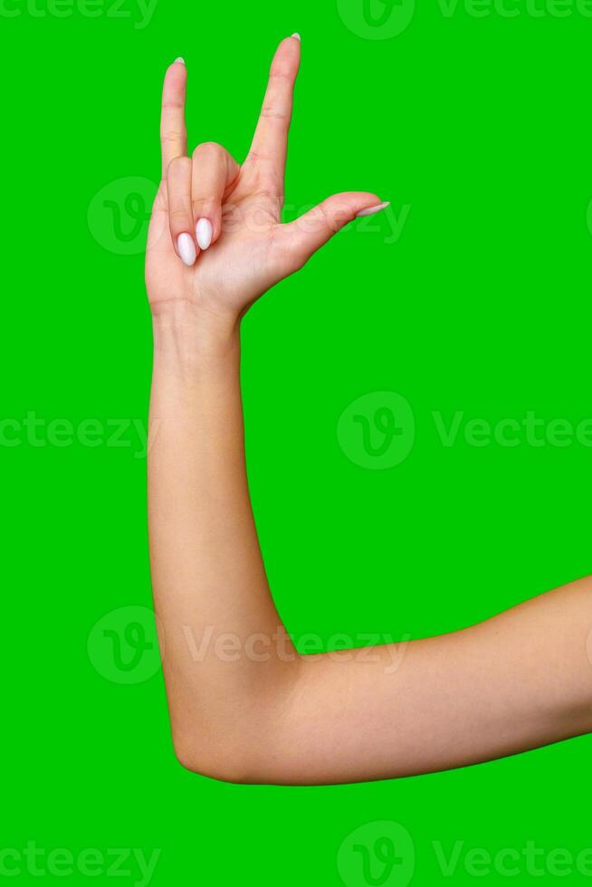 Woman's Hand Making I Love You Hand Gesture Against Green Screen photo