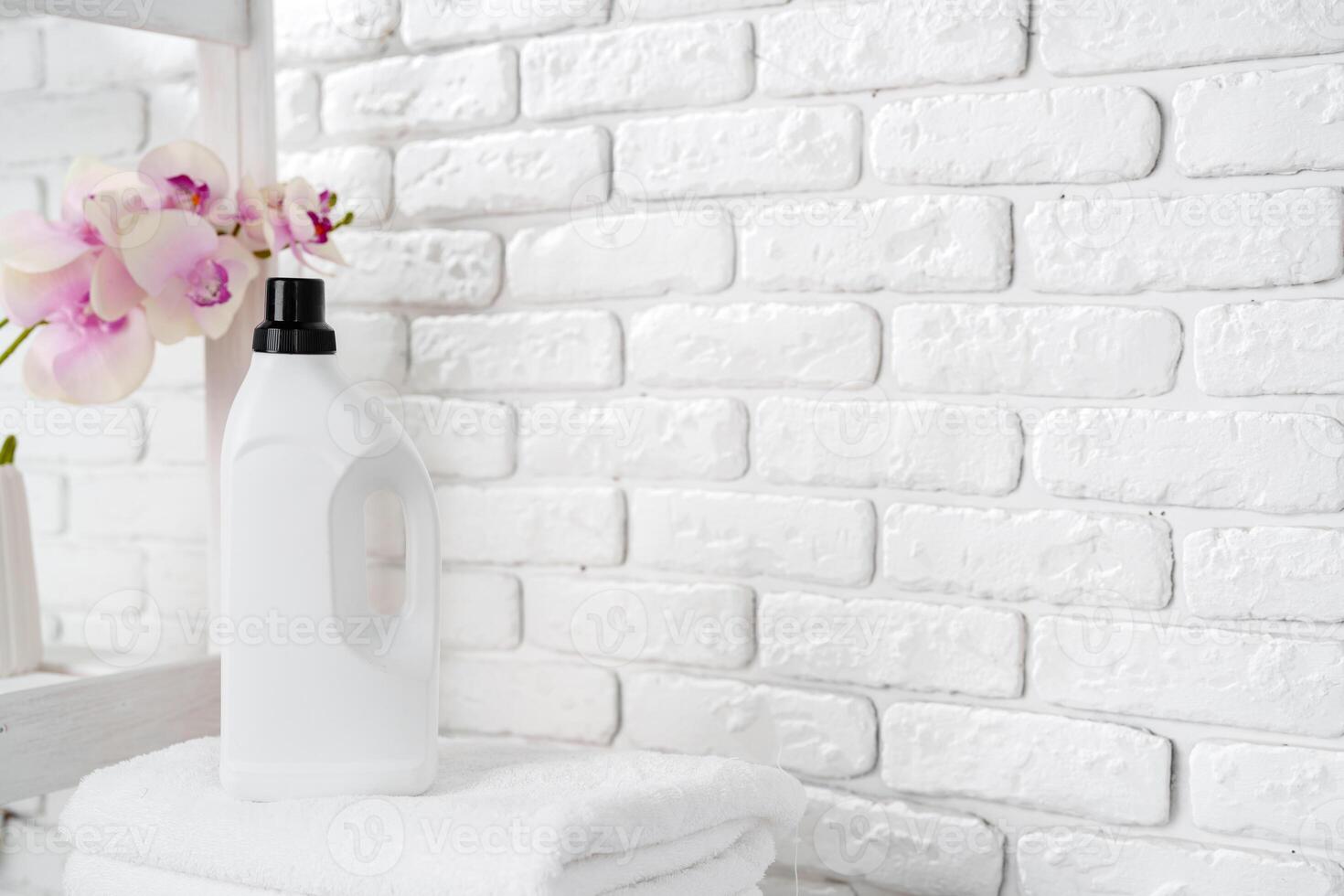 Laundry Detergent Bottles and Stacked Towels On Top of a Washing Machine photo