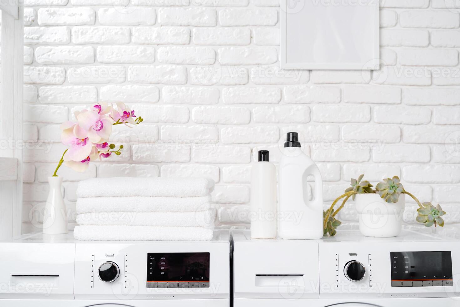 Two White Front Loading Washing Machines in Modern Laundry Room photo