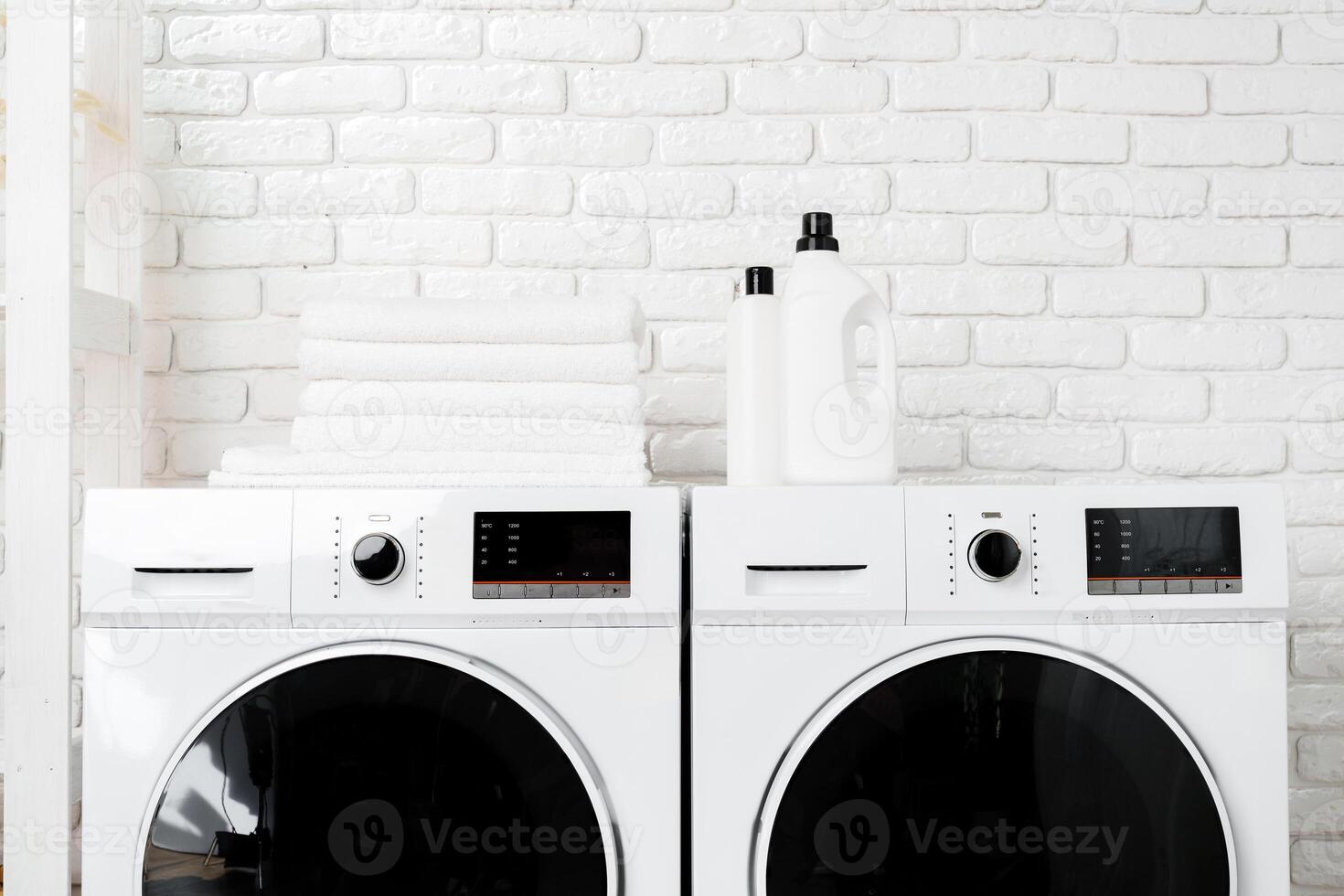 Two White Front Loading Washing Machines in Modern Laundry Room photo