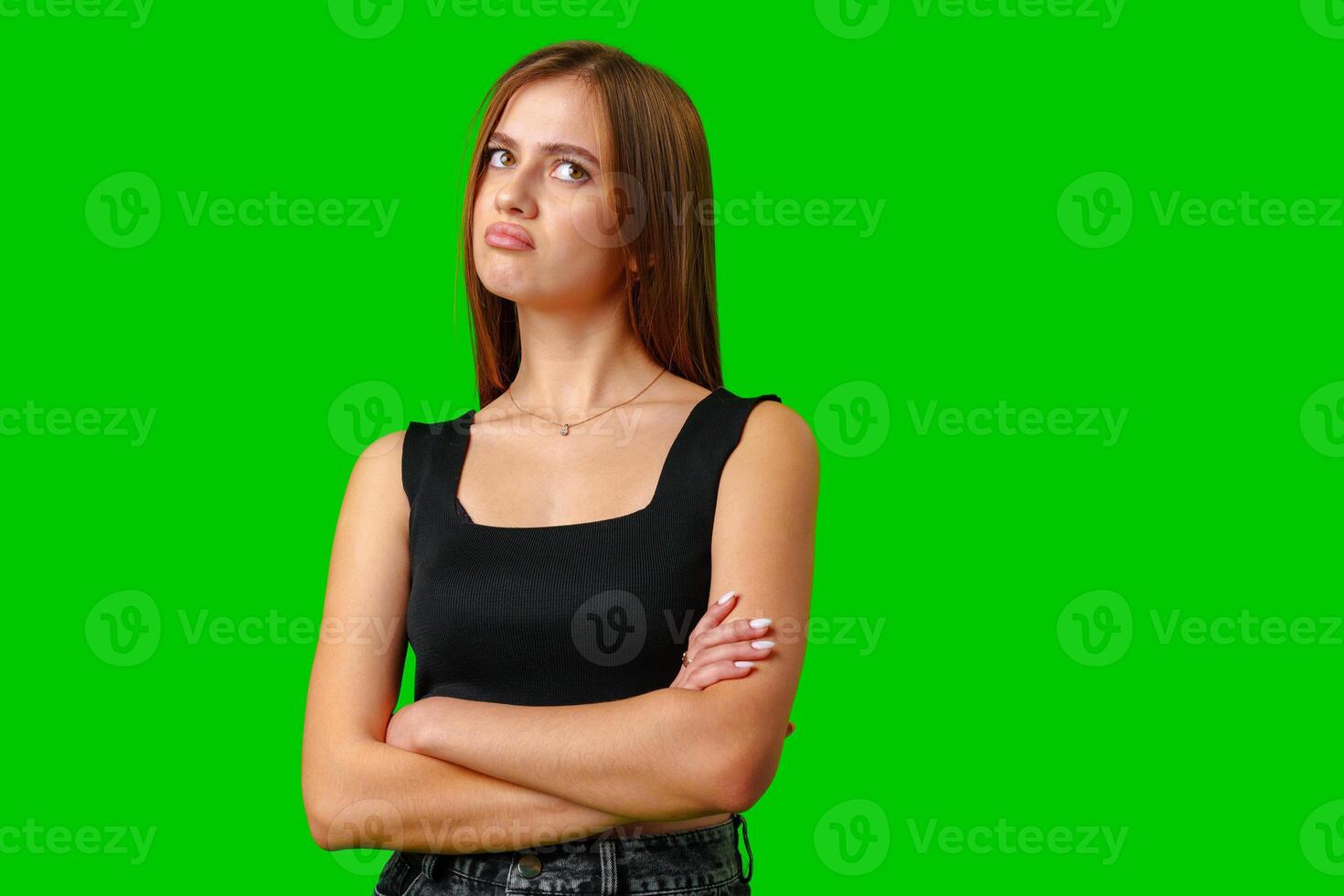 Young Woman With Arms Crossed in Front of Green Screen photo