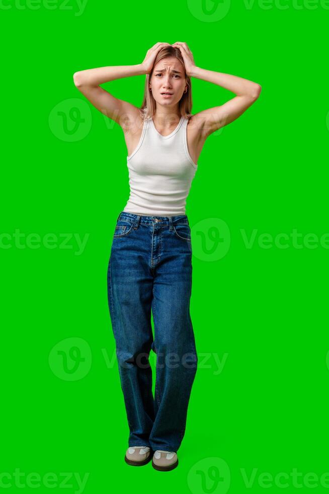 Young Woman Holding Her Head In Frustration On Green Screen photo
