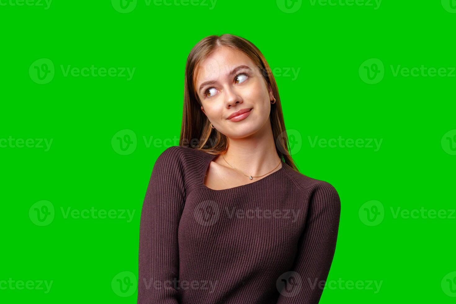 Young Woman Looking Up and to the Right in Front of a Green Screen photo